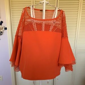 This brand new beautiful orange top with the beautiful large sleeves